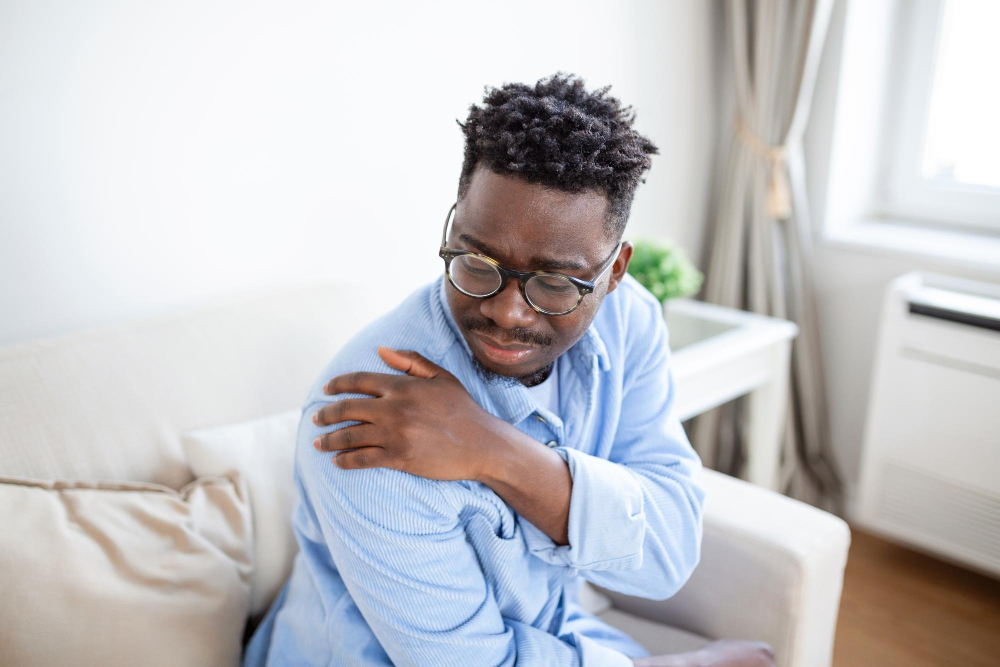 Person experiencing shoulder pain, illustrating common shoulder pain symptoms