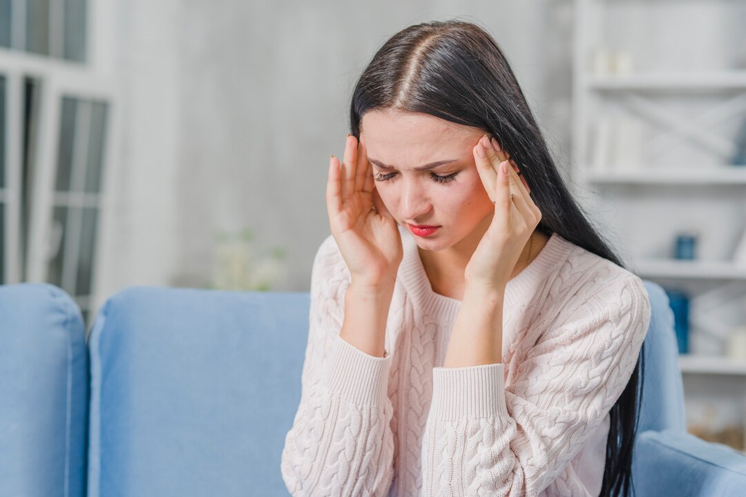 Young woman experiencing a headache, illustrating common headache symptoms